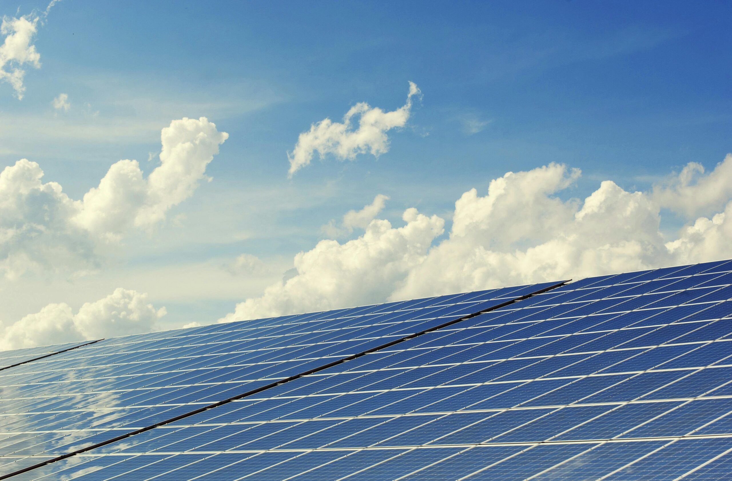 pexels-photo-356036-356036 | Maharishi vastu arkitektur Sleek modern solar panels under a vibrant blue sky with clouds, symbolizing clean energy.